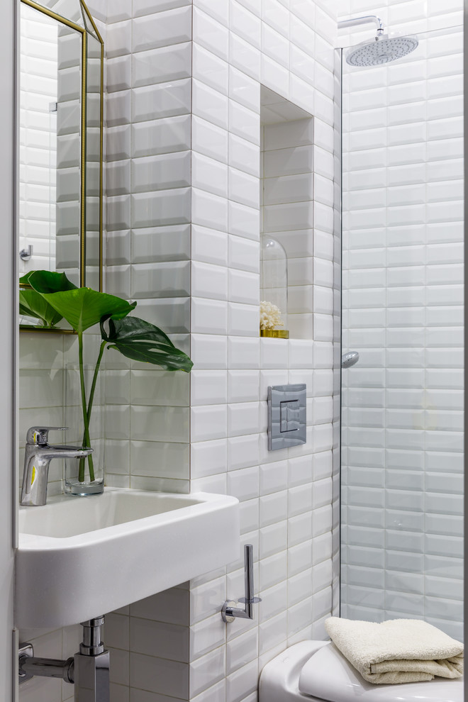 This is an example of a contemporary powder room in Other with a two-piece toilet, white tile and a wall-mount sink.