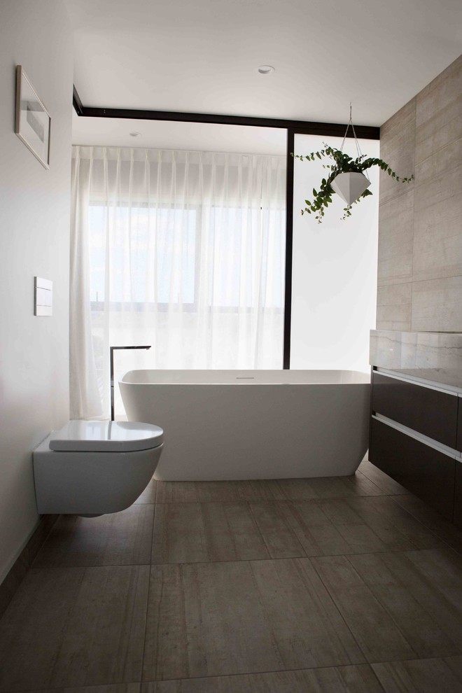 Design ideas for a modern bathroom in Auckland with a freestanding tub, an open shower, a wall-mount toilet, gray tile, ceramic tile, white walls, ceramic floors, an undermount sink, granite benchtops, grey floor, an open shower and grey benchtops.