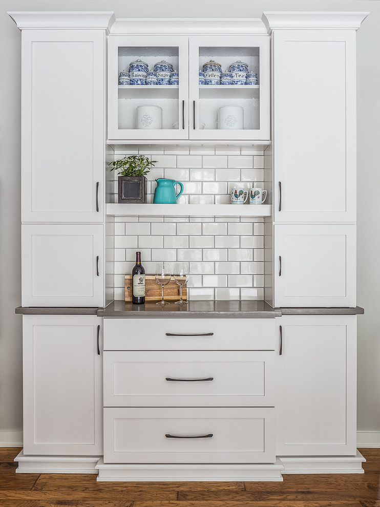 Eat-in kitchen - large transitional l-shaped eat-in kitchen idea with a drop-in sink, recessed-panel cabinets, white cabinets, quartzite countertops, white backsplash, stainless steel appliances and an island