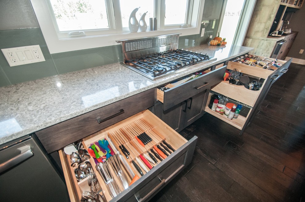 Inspiration for a large rustic dark wood floor and brown floor eat-in kitchen remodel with an undermount sink, flat-panel cabinets, medium tone wood cabinets, quartz countertops, green backsplash, glass sheet backsplash, stainless steel appliances and an island