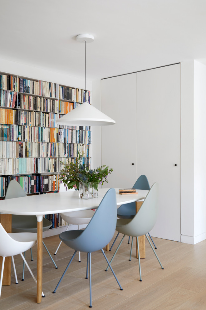 Idee per una piccola sala da pranzo aperta verso il soggiorno minimal con pareti bianche e parquet chiaro
