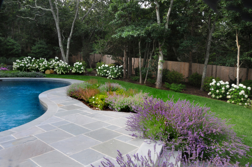 This is an example of a large country backyard full sun garden in New York with concrete pavers.