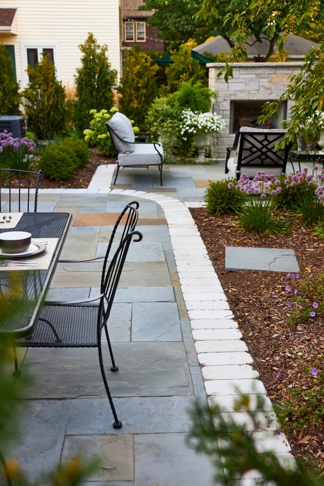 Backyard full sun garden in Milwaukee with natural stone pavers for summer.