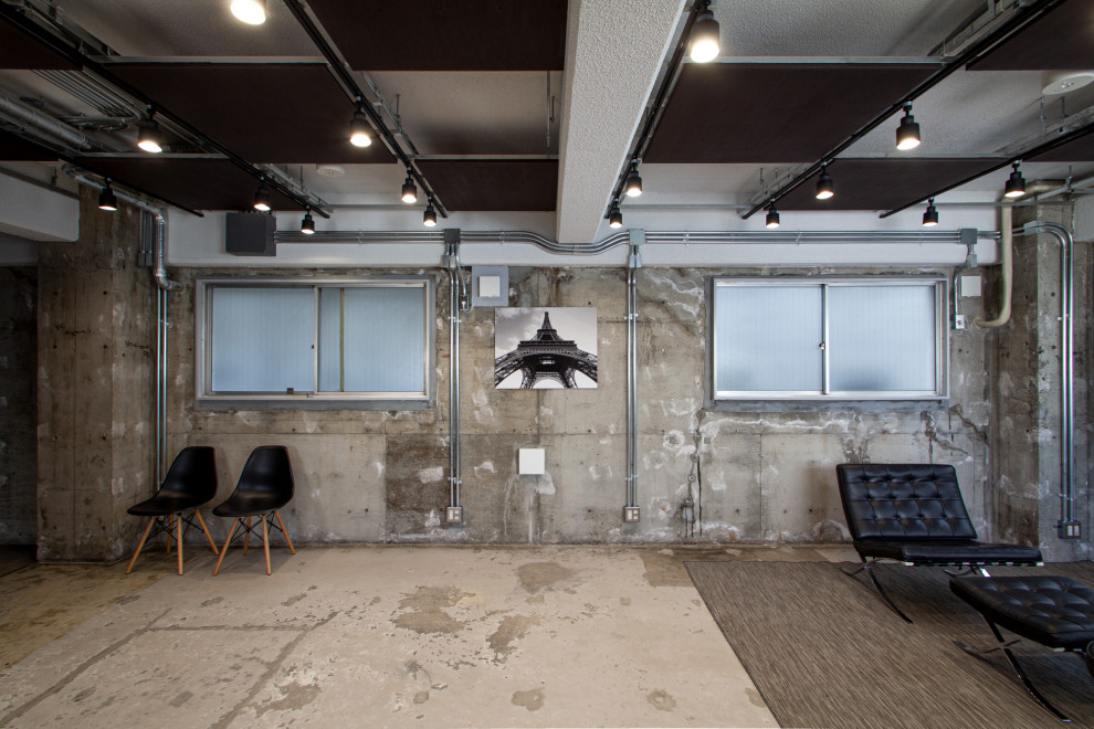 Cette photo montre un bureau industriel de taille moyenne et de type studio avec un mur gris, sol en béton ciré, aucune cheminée, un bureau indépendant, un sol gris et un plafond à caissons.