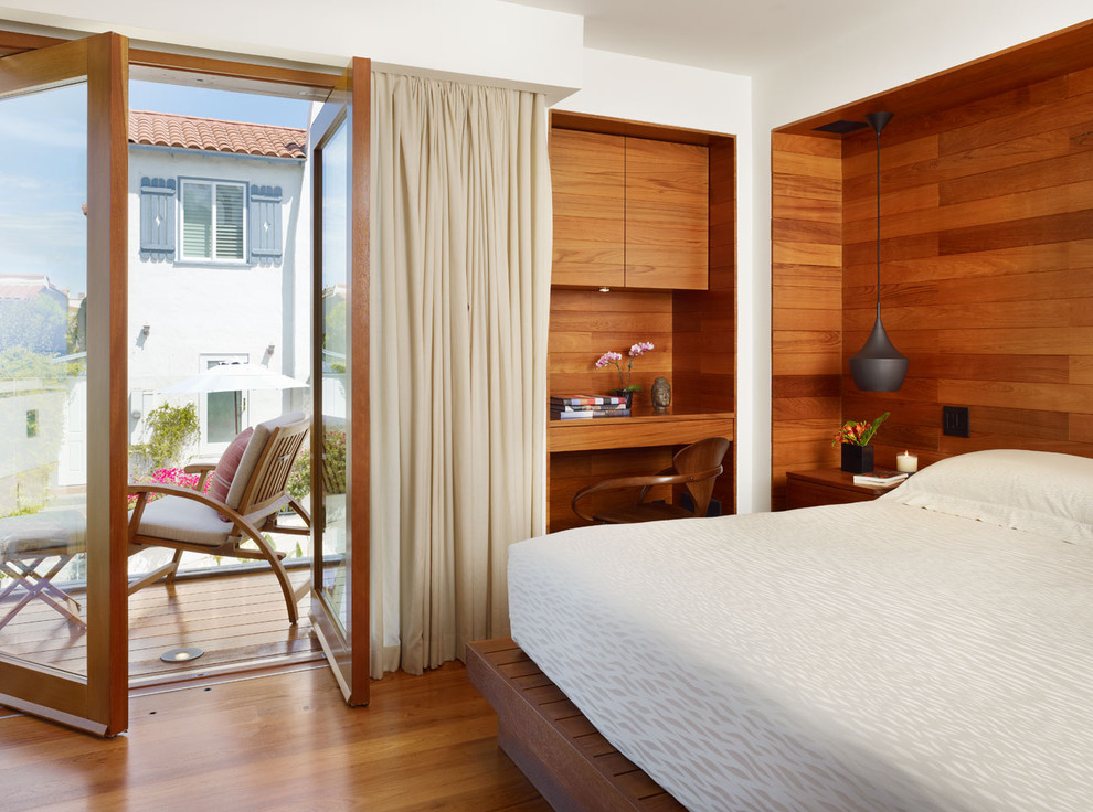 Photo of a mid-sized tropical master bedroom in Los Angeles with brown walls, dark hardwood floors and brown floor.