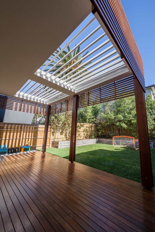This is an example of a mid-sized contemporary backyard deck in Melbourne with a pergola.
