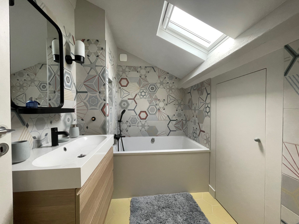 This is an example of a small scandinavian family bathroom in Bordeaux with a submerged bath, a one-piece toilet, multi-coloured tiles, a console sink, an open shower and white worktops.