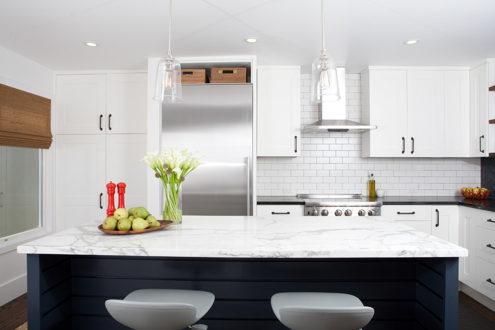 Photo of a midcentury separate kitchen in San Francisco with subway tile splashback, stainless steel appliances, shaker cabinets, white cabinets, marble benchtops and white splashback.