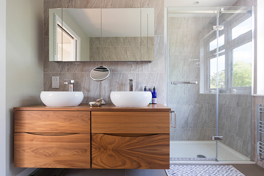 Inspiration for a mid-sized contemporary kids bathroom in London with flat-panel cabinets, medium wood cabinets, a freestanding tub, an open shower, a wall-mount toilet, brown tile, ceramic tile, ceramic floors, a trough sink, wood benchtops, brown floor, a hinged shower door and brown benchtops.