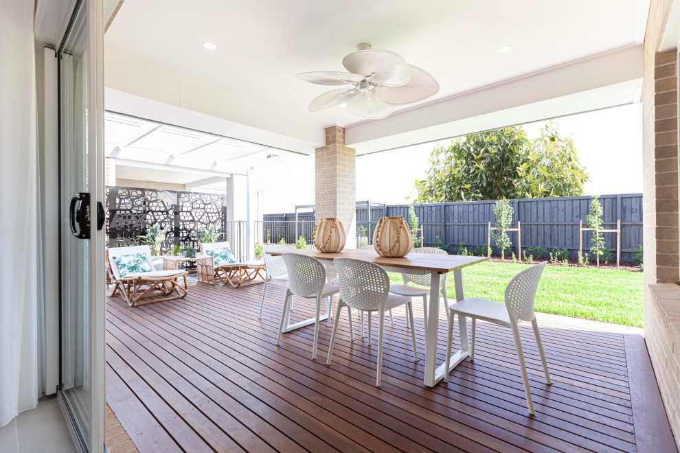 Design ideas for a tropical backyard patio in Melbourne with decking and a roof extension.