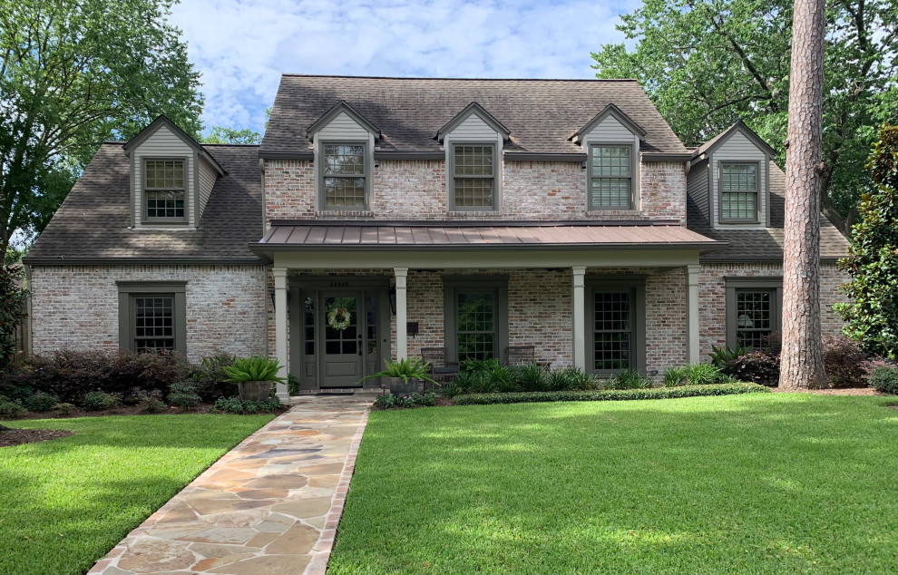 Inspiration for a large traditional two-storey brick grey house exterior in Houston with a hip roof and a shingle roof.