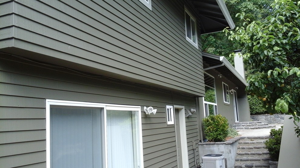 Design ideas for a traditional two-storey green exterior in Portland with vinyl siding.