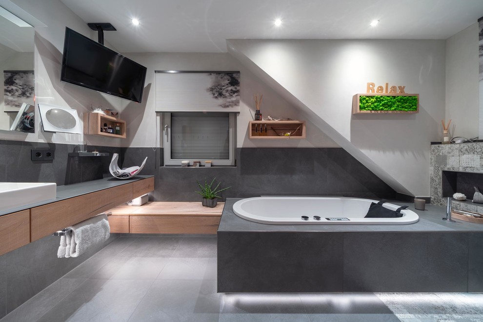Design ideas for a large contemporary bathroom in Stuttgart with light wood cabinets, a hot tub, a curbless shower, a two-piece toilet, gray tile, stone tile, white walls, ceramic floors, with a sauna, a vessel sink, grey floor, a hinged shower door and brown benchtops.