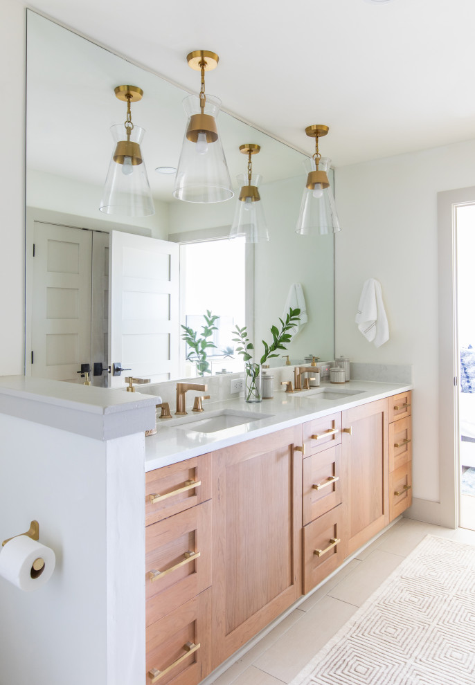 Beach style bathroom in Jacksonville with shaker cabinets, medium wood cabinets, white walls, an undermount sink, beige floor, white benchtops, a double vanity and a built-in vanity.