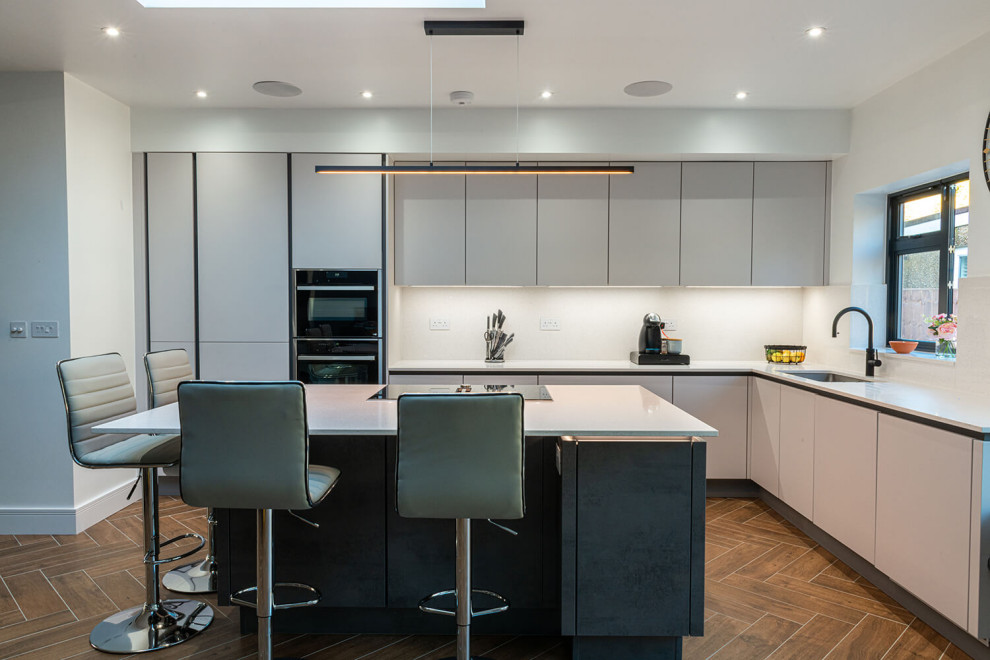 На фото: угловая кухня среднего размера в стиле модернизм с обеденным столом и островом с