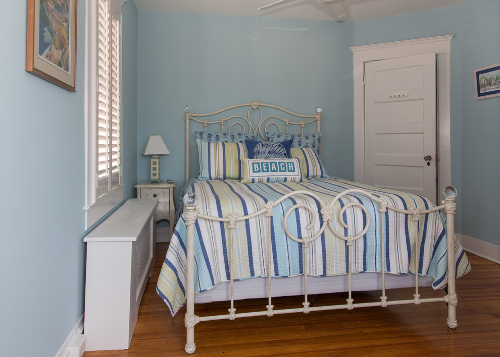 Design ideas for a mid-sized beach style guest bedroom in New York with blue walls, light hardwood floors and no fireplace.