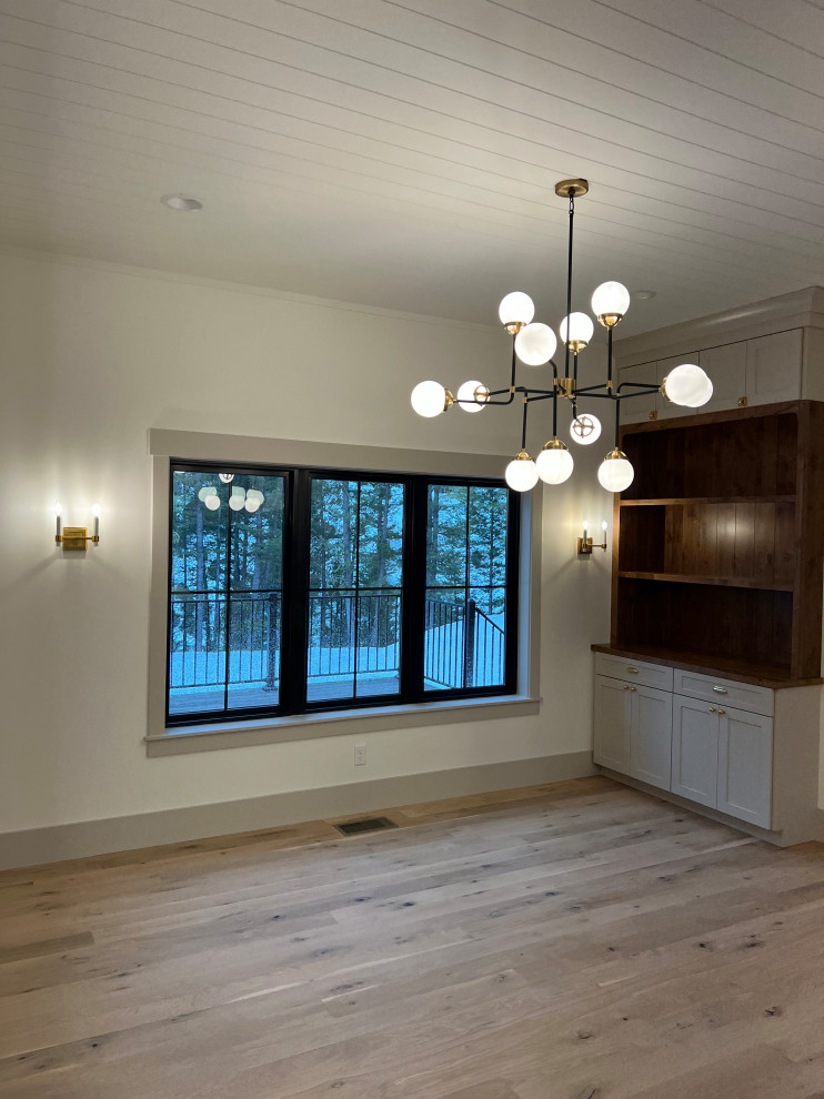Inspiration pour une salle à manger ouverte sur la cuisine traditionnelle de taille moyenne avec un mur beige, parquet clair et un plafond en lambris de bois.