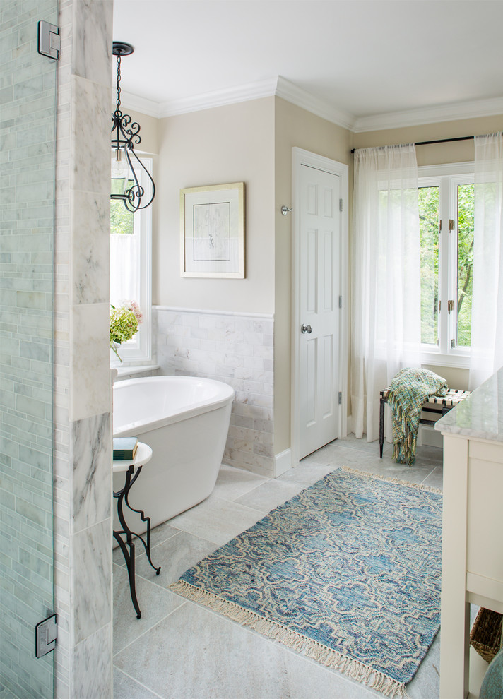 Design ideas for a large transitional master bathroom in Atlanta with an undermount sink, shaker cabinets, white cabinets, marble benchtops, a freestanding tub, an alcove shower, a one-piece toilet, gray tile, stone tile and beige walls.