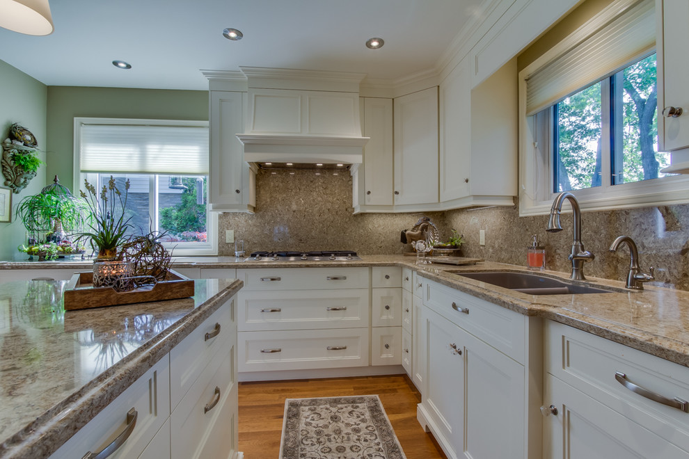 Example of a mid-sized transitional l-shaped medium tone wood floor eat-in kitchen design in Toronto with an undermount sink, shaker cabinets, white cabinets, quartzite countertops, brown backsplash, stone slab backsplash, stainless steel appliances and an island