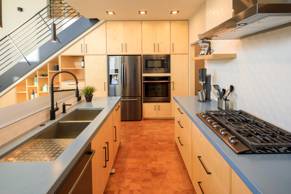 Medium sized modern galley kitchen/diner in Denver with a double-bowl sink, recessed-panel cabinets, light wood cabinets, concrete worktops, white splashback, cement tile splashback, cork flooring, no island, beige floors, blue worktops and a vaulted ceiling.
