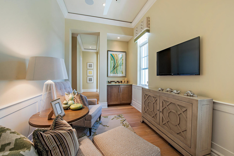 Small transitional enclosed medium tone wood floor and brown floor family room photo in Miami with beige walls, a wall-mounted tv and no fireplace