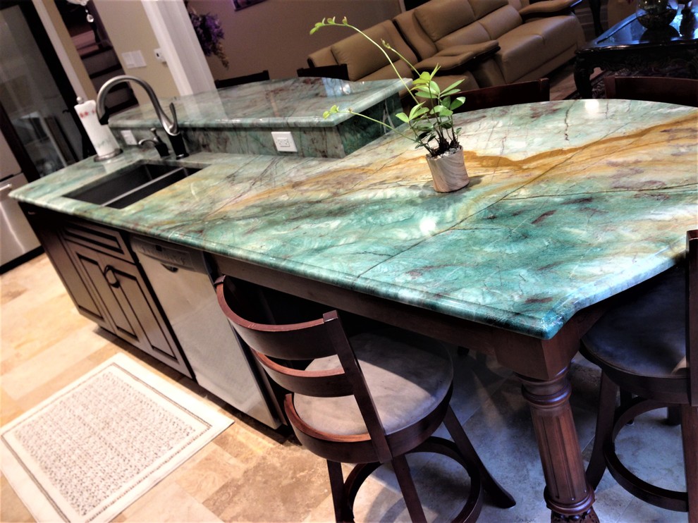 Eat-in kitchen - mid-sized transitional travertine floor and beige floor eat-in kitchen idea in Chicago with a double-bowl sink, raised-panel cabinets, dark wood cabinets, quartzite countertops, beige backsplash, stone tile backsplash, stainless steel appliances and an island