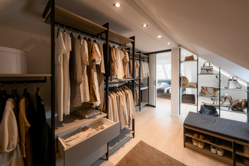 Diseño de armario vestidor de mujer minimalista de tamaño medio con armarios abiertos, puertas de armario de madera oscura, suelo de madera en tonos medios y suelo marrón
