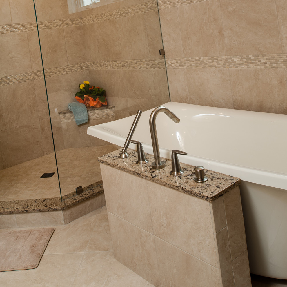 Inspiration for a large transitional master beige tile and stone tile porcelain tile freestanding bathtub remodel with an undermount sink, recessed-panel cabinets, medium tone wood cabinets, granite countertops and beige walls