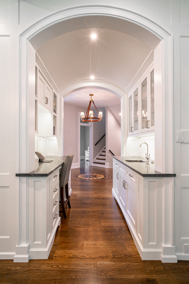 Design ideas for a large hallway in Philadelphia with white walls, dark hardwood floors, brown floor and vaulted.