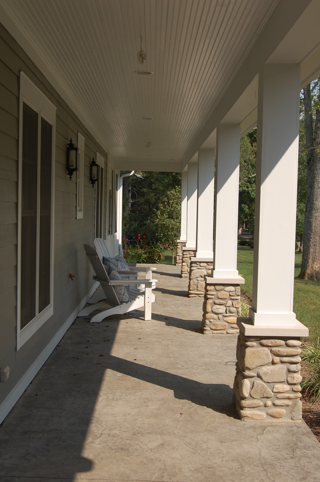 Photo of a mid-sized traditional front yard verandah in Cincinnati with a roof extension.
