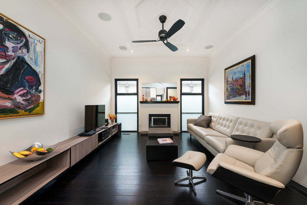 Inspiration for a contemporary formal living room in Melbourne with white walls, dark hardwood floors, a standard fireplace and a freestanding tv.