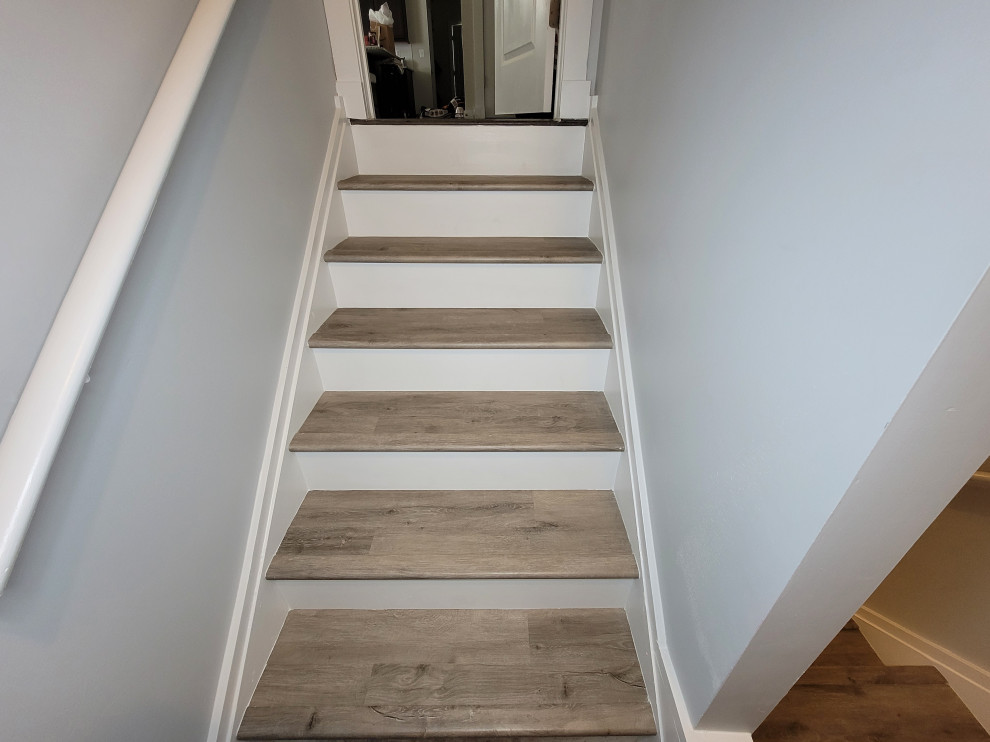 Cette image montre un escalier design en U de taille moyenne avec des marches en bois, des contremarches en bois et un garde-corps en bois.