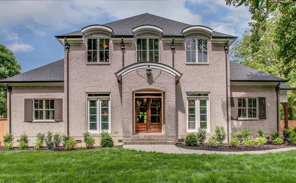 Photo of a traditional two-storey brick grey exterior in Nashville with a hip roof.