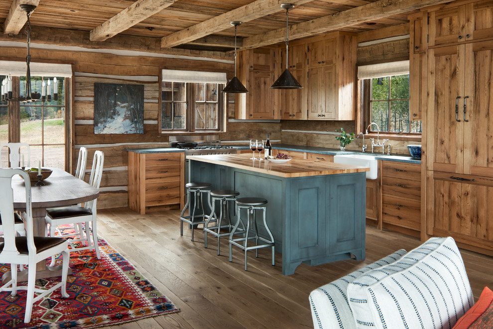 Inspiration for a country l-shaped open plan kitchen in Other with a farmhouse sink, shaker cabinets, medium wood cabinets, wood benchtops, brown splashback, timber splashback, panelled appliances, light hardwood floors, with island, beige floor and turquoise benchtop.
