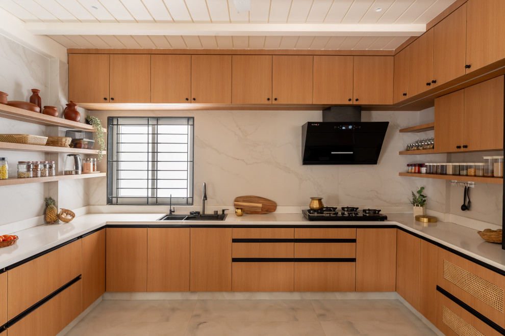 This is an example of a contemporary U-shaped kitchen in Bengaluru With an Undermount Sink, Flat-panel Cabinets, Medium Wood Cabinets, White Splashback, Stone Slab Splashback, No Island and Gray.
