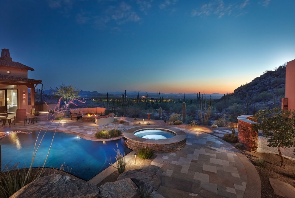 Inspiration for a mid-sized backyard custom-shaped pool in Phoenix with a hot tub and natural stone pavers.