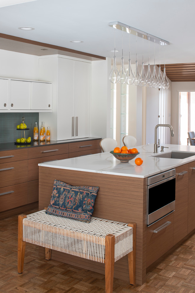 Design ideas for a mid-sized midcentury galley eat-in kitchen in Minneapolis with an undermount sink, flat-panel cabinets, quartz benchtops, grey splashback, stainless steel appliances, light hardwood floors, with island and brown floor.