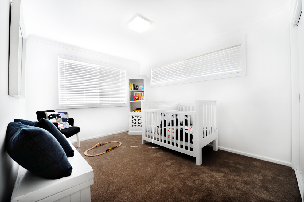 Design ideas for a small beach style nursery for boys in Other with white walls, carpet and brown floor.
