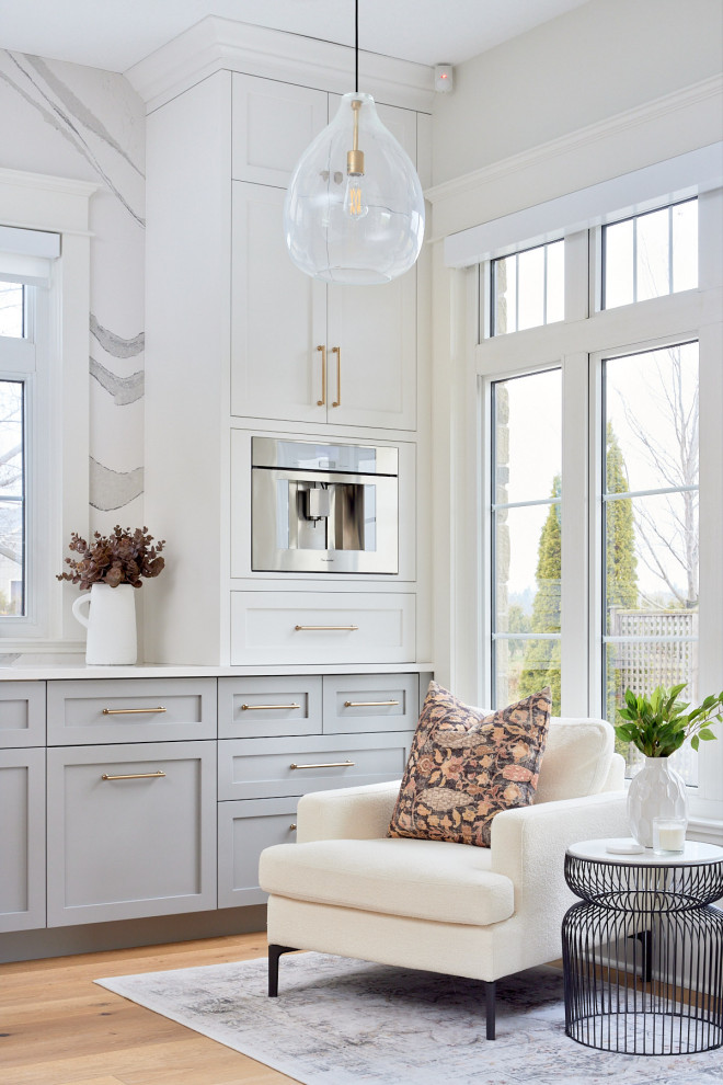 Mid-sized transitional single-wall medium tone wood floor and brown floor eat-in kitchen photo with an undermount sink, shaker cabinets, blue cabinets, quartz countertops, multicolored backsplash, quartz backsplash, stainless steel appliances, a peninsula and white countertops
