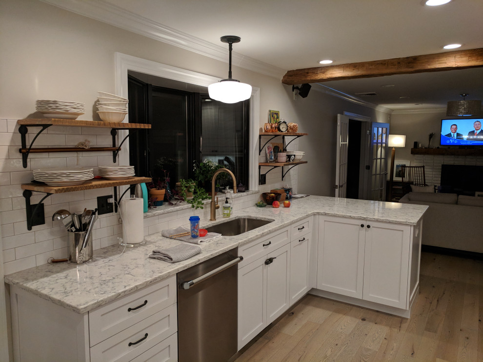Inspiration for a mid-sized transitional l-shaped ceramic tile and brown floor eat-in kitchen remodel with an undermount sink, recessed-panel cabinets, white cabinets, quartz countertops, white backsplash, subway tile backsplash, stainless steel appliances, no island and white countertops