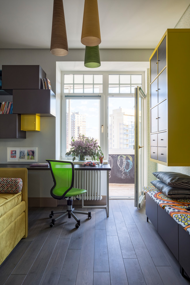 This is an example of a contemporary gender-neutral kids' study room in Moscow with white walls, dark hardwood floors and black floor.