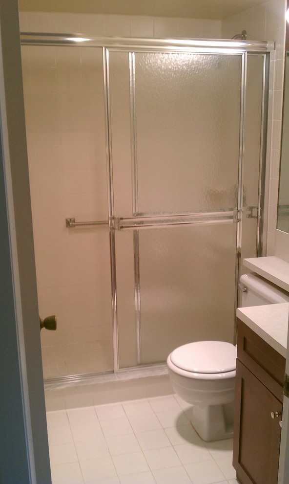 Alcove shower - mid-sized transitional master ceramic tile alcove shower idea in Miami with shaker cabinets, dark wood cabinets, a two-piece toilet and beige walls