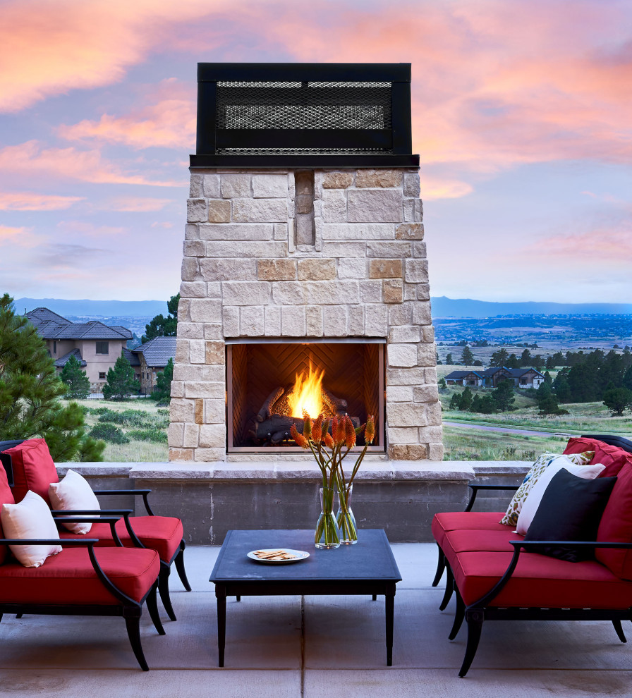 Design ideas for a large country backyard patio in Denver with with fireplace, concrete slab and no cover.