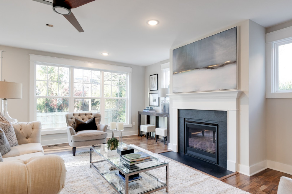 Example of a mid-sized classic open concept medium tone wood floor and brown floor family room design in Richmond with gray walls, a standard fireplace and a wood fireplace surround