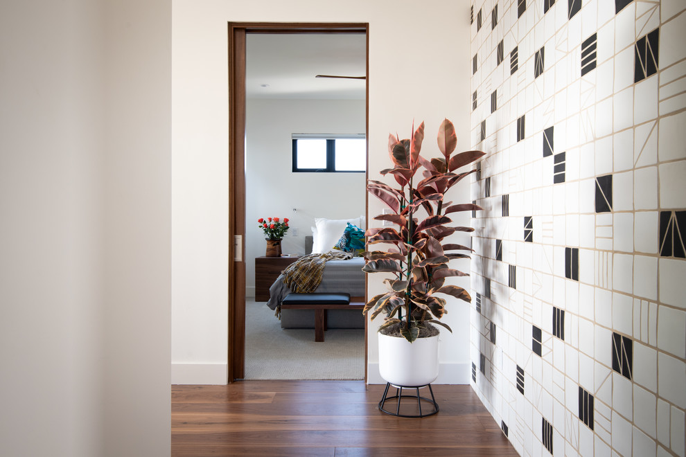 This is an example of a mid-sized midcentury hallway in San Diego with white walls, medium hardwood floors and brown floor.