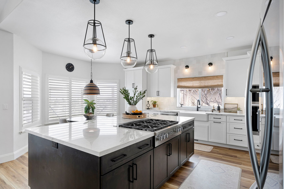 Kitchen - transitional vinyl floor and brown floor kitchen idea with a farmhouse sink, shaker cabinets, white cabinets, quartzite countertops, white backsplash and stainless steel appliances