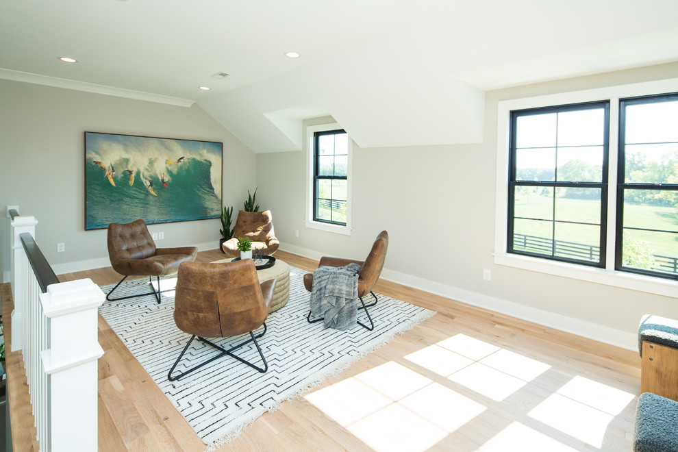 This is an example of a transitional living room in Columbus with grey walls and light hardwood floors.