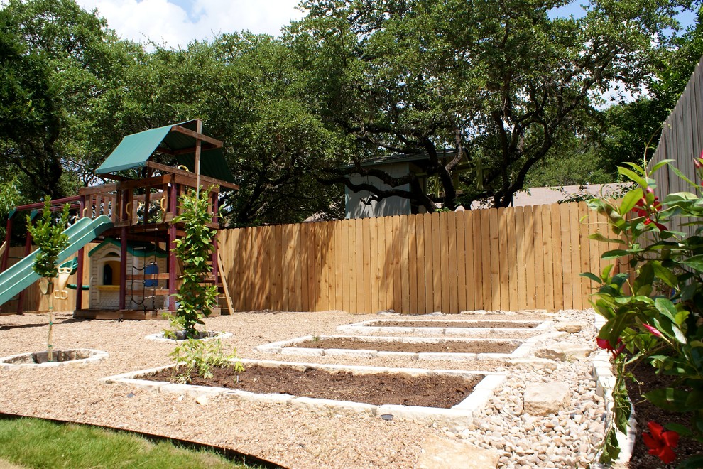 This is an example of a small contemporary backyard partial sun xeriscape for spring in Austin with natural stone pavers.