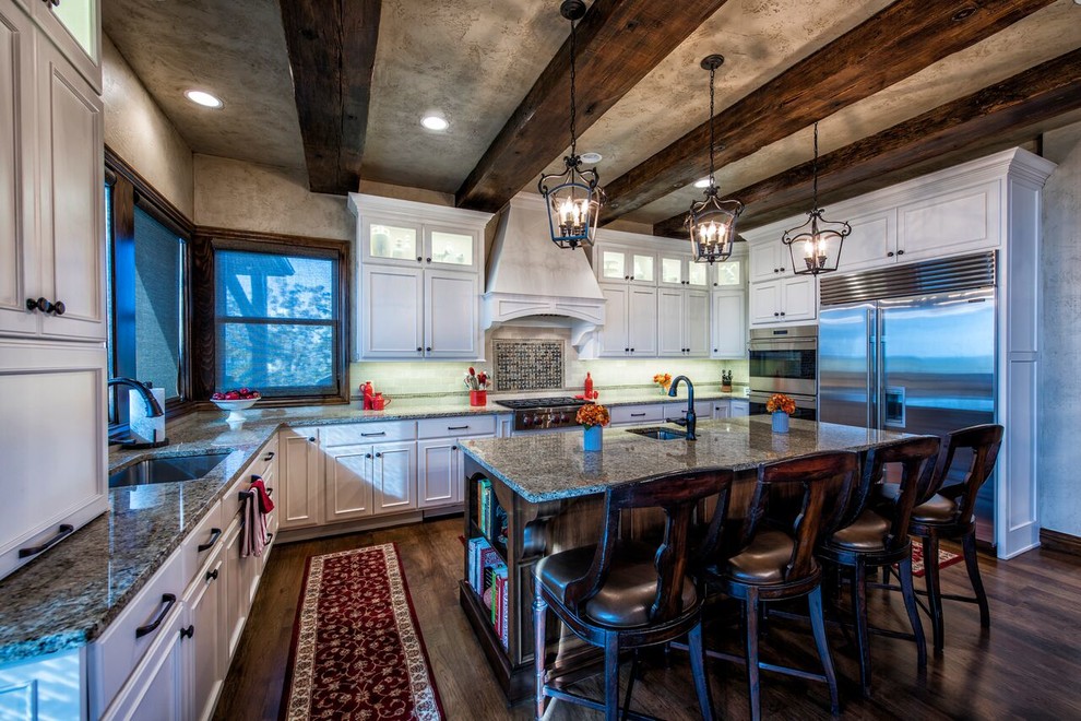 Large mountain style u-shaped dark wood floor kitchen photo with an undermount sink, beaded inset cabinets, white cabinets, granite countertops, white backsplash, stainless steel appliances and an island