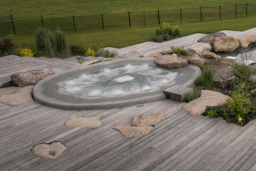 Immagine di una grande piscina classica personalizzata dietro casa con una vasca idromassaggio e pedane
